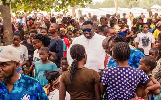 Fr. Remigius Ihyula accompanies internally displaced persons at the Uikpam camp in Benue State, Nigeria. Since 2017, Ihyula has responded to Benue's worsening humanitarian crisis, making the camps his second parish and offering pastoral care and counseling to traumatized survivors. (John Chukwu)