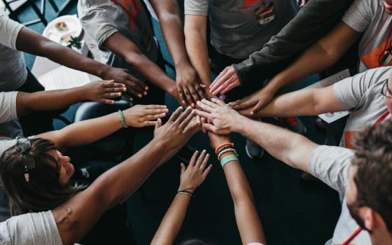 Hands meeting at the center of a huddle