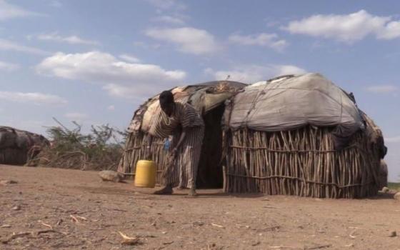 Jemima Cheruto bends to fetch water outside her home in Ortum, northern Kenya. 