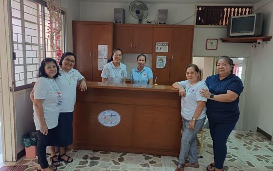 Srs. Flor Montoja Manga (second from left) and Linlee Vios (center) of the Adorers of the Blood of Christ share smiles with their lay collaborators at the St. Maria De Mattias Mission Center in Quezon City. Together, they run the clinic that has served the poor for more than 30 years through faith, compassion, and community partnership. (Oliver Samson)