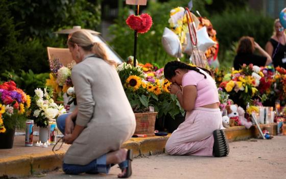 People pray at a memorial at Annunciation Catholic Church Aug. 28 in Minneapolis.