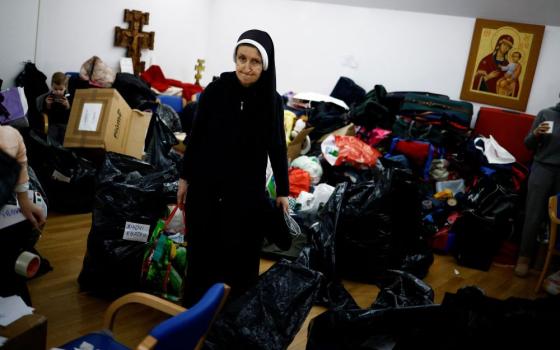 A nun carries humanitarian goods to be loaded onto trucks as first aid transport to Ukraine at the Basilica of Santa Sofia, a religious and cultural center for Ukrainian expatriates in Rome, on March 3. (CNS/Reuters/Guglielmo Mangiapane)