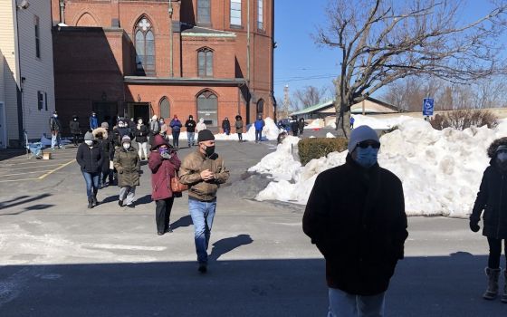 Parishioners walk on the snow-cleared parking lot of St. Patrick Church in Lawrence, Massachusetts, to assemble in winter for Mass outdoors. (Courtesy of St. Patrick Parish)