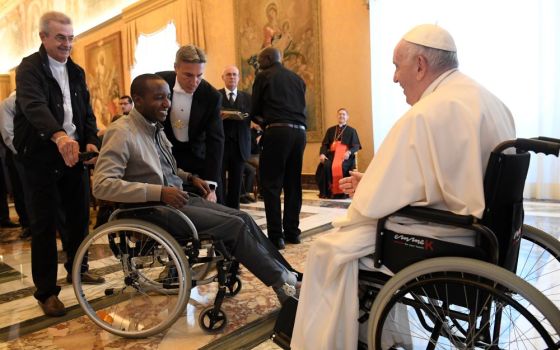 Pope Francis greets a cleric in a wheelchair during an audience with participants attending the general chapter of the Comboni Missionaries at the Vatican June 18, 2022. (CNS/Vatican Media)