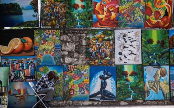 A street art vendor In Port-au-Prince, Haiti, prays about a week after the July 7 assassination of Haitian President Jovenel Moïse. (CNS