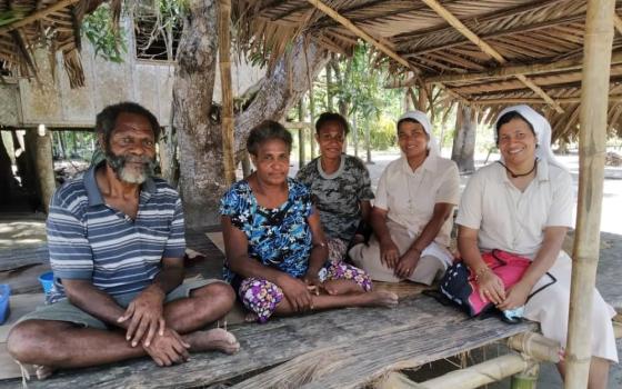 Sr. Shephali Khalko of the Missionary Sisters of the Immaculate, second from right, conducts a family visit with another nun in Gulf Province in Papua New Guinea. She has been working in the country for 10 years. (Courtesy of Shephali Khalko)