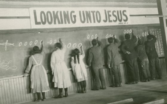 In this 1910s photo, students write on a chalkboard at the Red Deer Indian Industrial School in Alberta. (AP/United Church of Canada Archives)