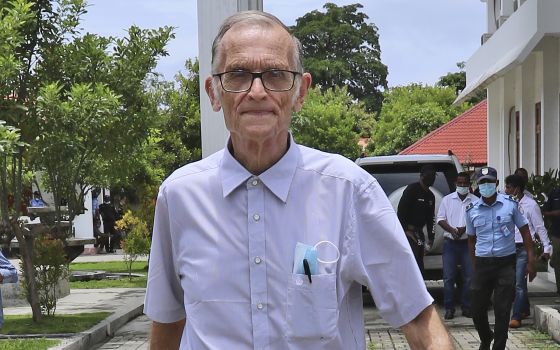 Richard Daschbach, a former missionary from Pennsylvania, is escorted by a police officer upon his arrival for a trial at a courthouse in Oecusse, East Timor on Feb. 23, 2021. (AP Photo/Raimundos Oki, File)