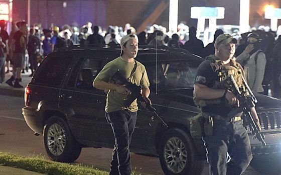 Kyle Rittenhouse, left, walks along Sheridan Road in Kenosha, Wisconsin, Tuesday, Aug. 25, 2020, with another armed civilian. (Adam Rogan/The Journal Times via AP)