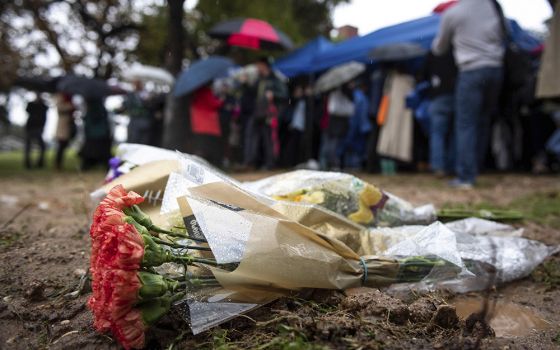 Flowers are left at the burial site of 1,457 unclaimed dead individuals in Los Angeles County from 2016 during an interfaith ceremony at the Los Angeles County Crematory and Cemetery, Dec. 4, 2019, in Los Angeles. (AP)