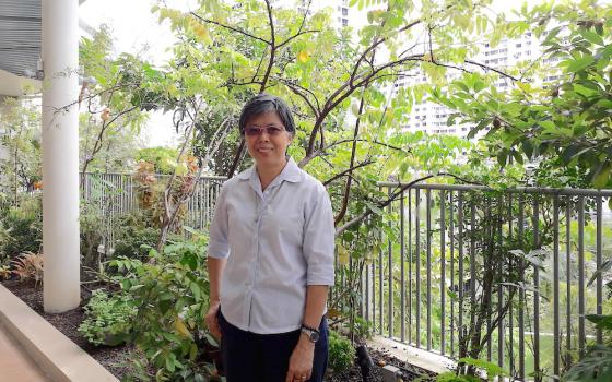 Good Shepherd Sr. Agnes-Claire Koh poses in front of the Good Shepherd Sisters' main convent; public housing can be seen in the background. (Provided photo)