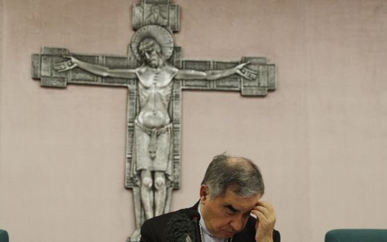 Cardinal Angelo Becciu looks down as he meets the media during a news conference in Rome