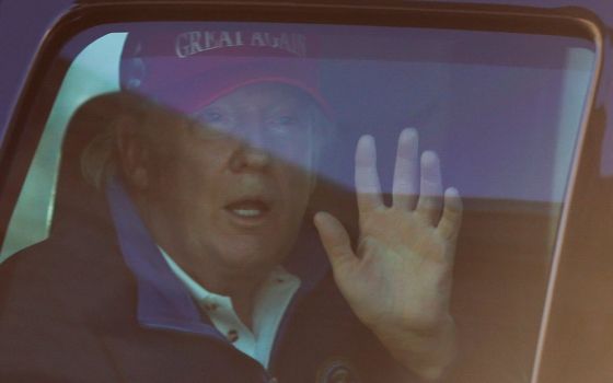 President Donald Trump waves to supporters in Washington Nov. 14, as he drives past Freedom Plaza upon his return from playing golf. (CNS/Reuters/Carlos Barria)