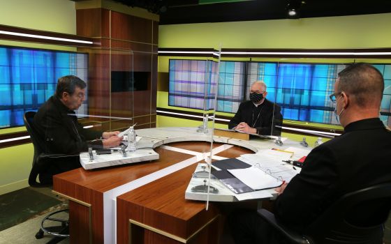 Detroit Archbishop Allen Vigneron, vice president of the U.S. Conference of Catholic Bishops, left, leads the opening prayer Nov. 17 at the conference's headquarters in Washington during the bishops' virtual fall meeting. Also pictured are Archbishop Jose