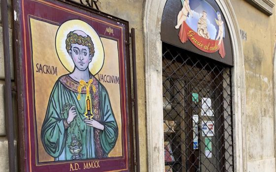 A poster of St. Stephen holding a "Holy Vaccine," by the Rome street artist known as Maupal, is seen near the Vatican Dec. 11. (CNS/Cindy Wooden)