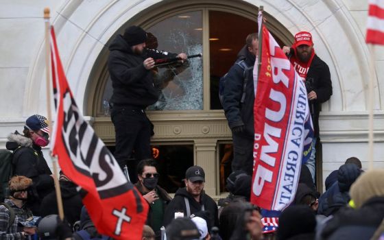 A President Donald Trump supporter breaks a window at the U.S. Capitol in Washington Jan. 6, 2021. (CNS/Reuters/Leah Millis)