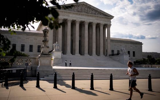 A person runs past the U.S. Supreme Court building in Washington June 25. (CNS/Reuters/Al Drago)