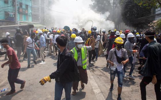 Protesters retreat after police opened fire to disperse an anti-coup protest in Mandalay, Myanmar, March 3, 2021.