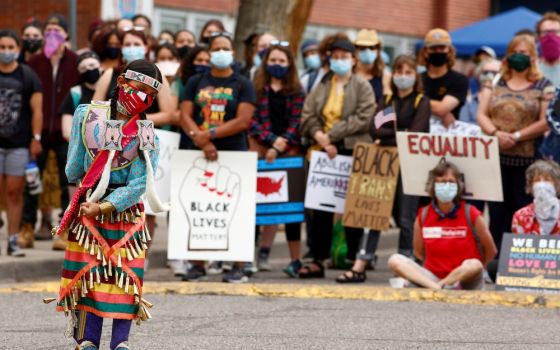 An indigenous girl in Denver dances in traditional dress July 4 during a march that called on Black, indigenous and Latino communities to rise up against oppression. (CNS/Reuters/Kevin Mohatt)