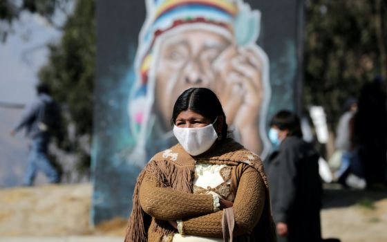 An Aymara woman wearing a protective mask stands at the blockade point set up by supporters of former President Evo Morales in El Alto, Bolivia, Aug. 10, when protesters were demanding quick presidential elections, postponed multiple times due to the COVI