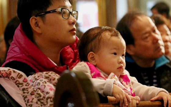 A man holds a child during Mass celebrated in February 2018 at Transfiguration Church in New York City. (CNS/Gregory A. Shemitz)