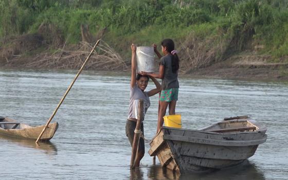 Two young women load buckets of water into their canoe on the Marañón River in Peru. (Quisca Producciones)