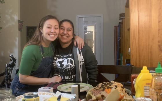 Two young women smiling in a kitchen