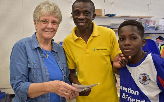 Notre Dame de Namur Sr. Mary Alice McCabe welcomes an Angolan father and son to the Humanitarian Respite Center in McAllen, Texas, in January 2020. (Courtesy of Mary Alice McCabe)