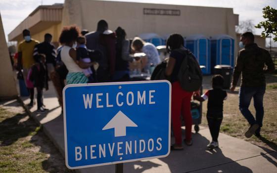 Migrants from Haiti wash clothes as they arrive March 21 at the Val Verde Border Humanitarian Coalition after being released from U.S. Customs and Border Protection in Del Rio, Texas. (CNS/Reuters/Adrees Latif)