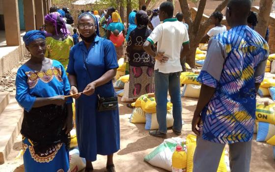 Sr. Ojonoka Acheneje, a Daughter of Charity of St. Vincent De Paul, distributes food to internally displaced persons in the Diocese of Nouna, Burkina Faso. (Courtesy of Janet E. Deinanaghan)