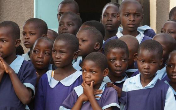 Kenyan schoolchildren listen to their teacher in June 2019 outside their classroom in Bungoma in western Kenya. According to UNESCO, the education of 1.54 billion pupils in 185 countries has been curtailed during the pandemic. (Doreen Ajiambo)