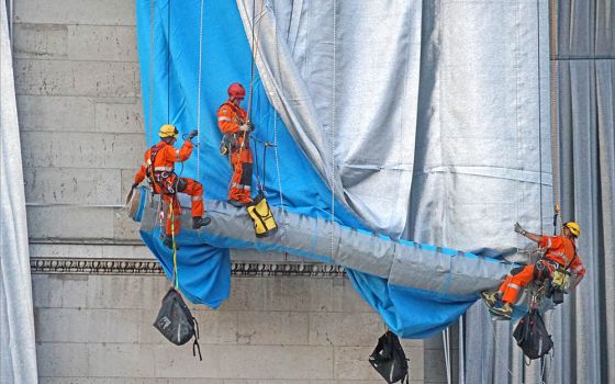 Workers wrap fabric on the southwest façade of the Arc de Triomphe in Paris Sept. 12. (Wikimedia Commons/Jean-Pierre Dalbéra)