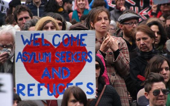 People at a Melbourne refugee and asylum seeker rights rally July 27, 2013, protest both the Rudd Labor Government new proposal for assessment and resettlement of asylum seekers in Papua New Guinea, and the Liberal Party's hard line stand to use the milit