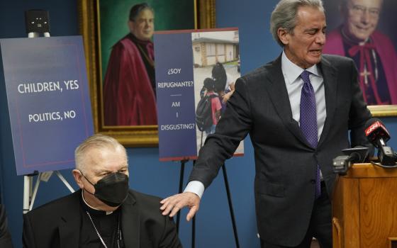 Tony Argiz, right, puts his hand on Archbishop of Miami Thomas Wenski 's shoulder as he speaks during a news conference, at the Archdiocese of Miami Pastoral Center in Miami Shores, Fla.,  Feb. 10, 2022, (AP Photo/Wilfredo Lee)