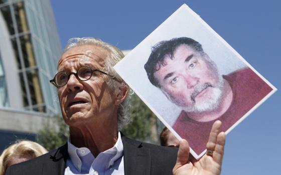 Attorney Jeff Anderson holds up a photo of former priest Stephen Kiesle at a news conference in Oakland, Calif., Wednesday, Aug. 18, 2010. (AP Photo/Jeff Chiu, File)