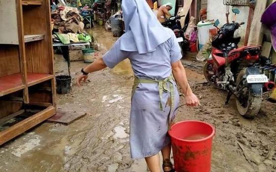 Sister of the Daughters of St. Anne helped residents clean up mud in Bagong Silangan, an area of Quezon City in metropolitan Manila after flooding caused by Typhoon Ulysses, the local name for Typhoon Vamco, which hit the region Nov. 11. (Courtesy of Daug