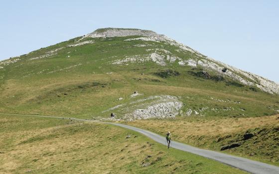 Person walking a path down a large hill