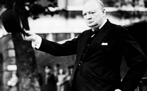 British Prime Minister Winston Churchill doffs his hat as he takes the salute as the Civil Service Home Guard marches by him on review on the Horse Guards Parade, Sept. 17, 1942. (AP photo)