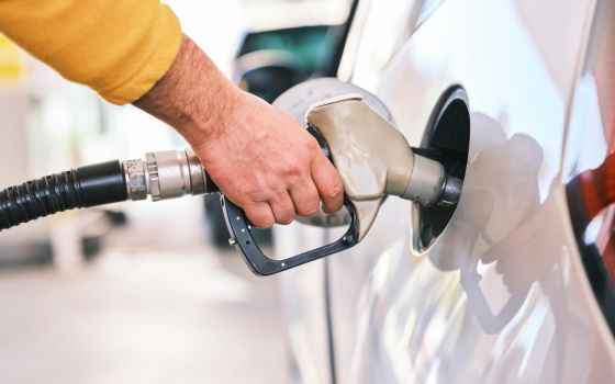 Person putting gasoline into car with nozzle. (Unsplash/Engin Akyurt)