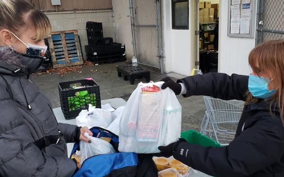 Hour Children food pantry participant and Queens resident Jackie Terrasi, left, receives a food package from pantry coordinator Kellie Phelan. The pantry, based in New York City, is an initiative of Hour Children, a ministry headed by St. Joseph Sr. Tesa 