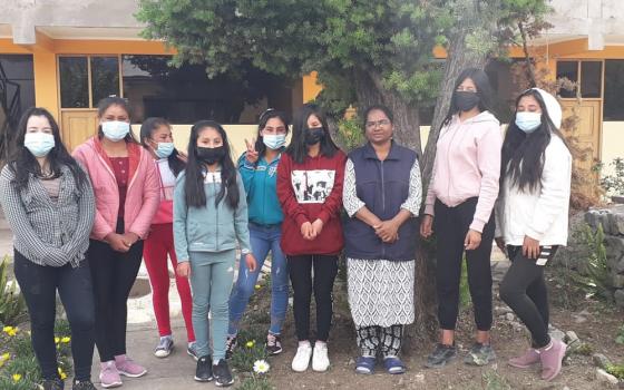 Sister Hilda, third from the right, stands with her students under an evergreen tree. The picture is taken outside Maria Reina, the sisters’ hostel, in the village of Curahuasi, Peru. (Courtesy of Hilda Mary Bernath)