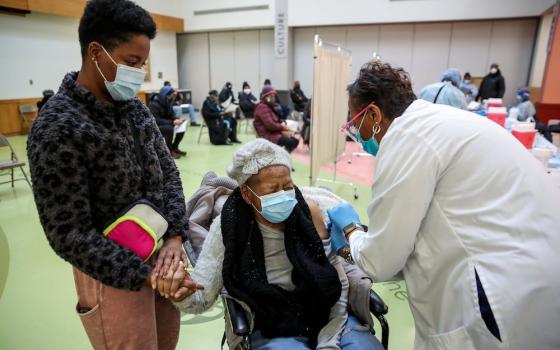 Juanta J. Gordon receives the COVID-19 vaccine from her daughter, nurse Zyra D. Gordon Smith, at Trinity United Church of Christ in Chicago Feb. 13. (CNS photo/Kamil Krzaczynski, Reuters)