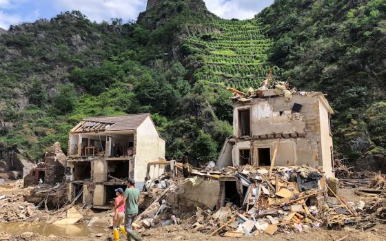 Residents walk past destroyed homes in Mayschoss, Germany, July 29, following historic flooding. At least 160 people have died in the flooding. Germany's churches plan to hold an ecumenical service in Aachen cathedral Aug. 28 to commemorate the victims. (