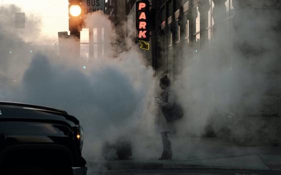 woman on street obscured by car exhaust