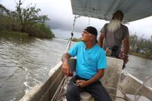 Donald Dardar, left, and Russell Dardar look toward the eroding shoreline of Bayou Pointe-au-Chien in southern Louisiana in September. The brothers have lived along the bayou all their lives as shrimpers and fishermen.(AP/Jessie Wardarski) 