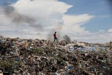 A man walks in a garbage dump in Kisumu, Kenya, April 18. (CNS/Baz Ratner, Reuters)