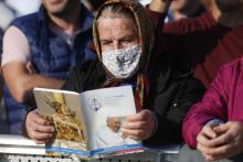 A woman holds the Mass program as she waits for Pope Francis' arrival to celebrate Mass on the plains of the Basilica of Our Lady of Seven Sorrows in Šaštin, Slovakia, Sept. 15, 2021. (CNS photo/Paul Haring)