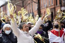 The faithful raise their palm fronds as they participate in a Palm Sunday procession April 10, 2022, in the Prospect Heights section of Brooklyn, New York. (CNS/Gregory A. Shemitz)