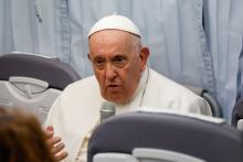 Pope holds microphone during press conference on plane