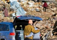 A couple hugs standing next to a truck looking at destruction from a tornado (Unsplash/Chandler Cruttenden)